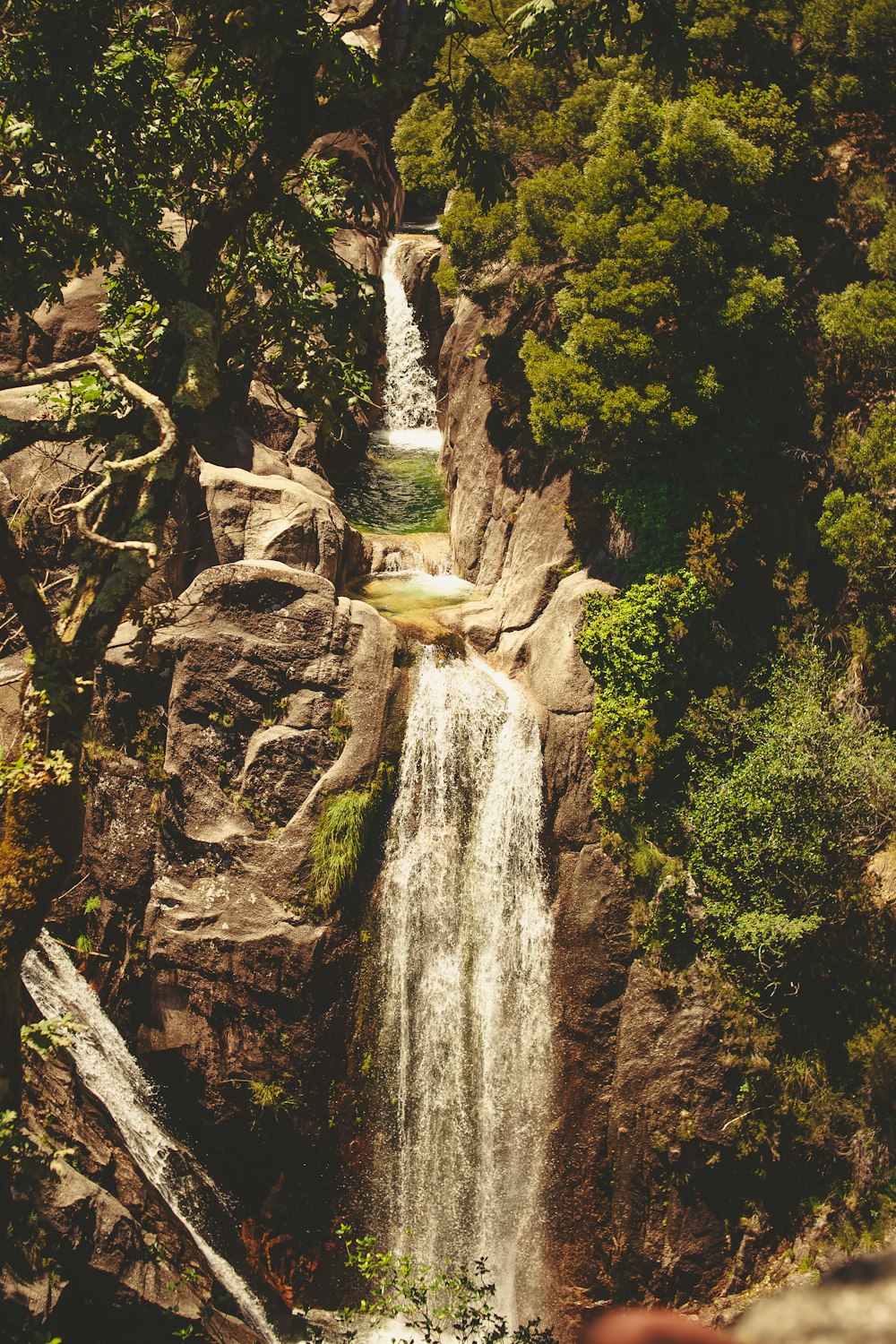 a large waterfall surrounded by trees and rocks