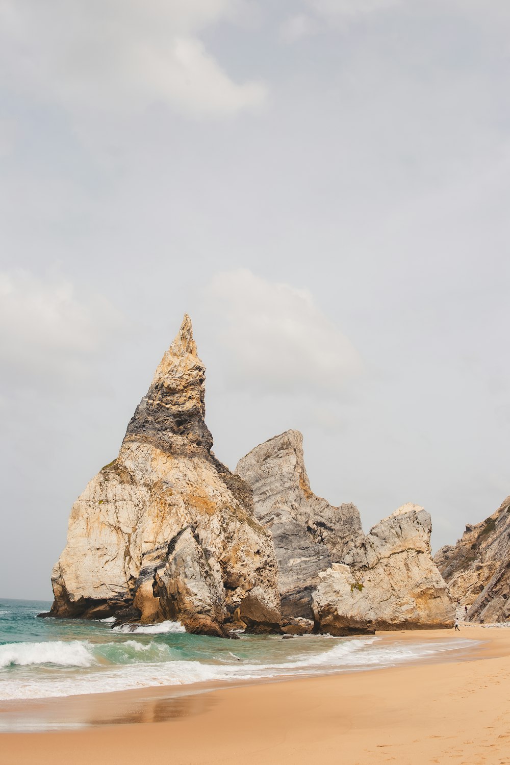 une grande formation rocheuse sur la plage près de l’océan