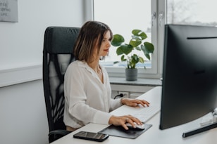 a woman sitting at a desk using a computer