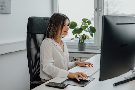 a woman sitting at a desk using a computer