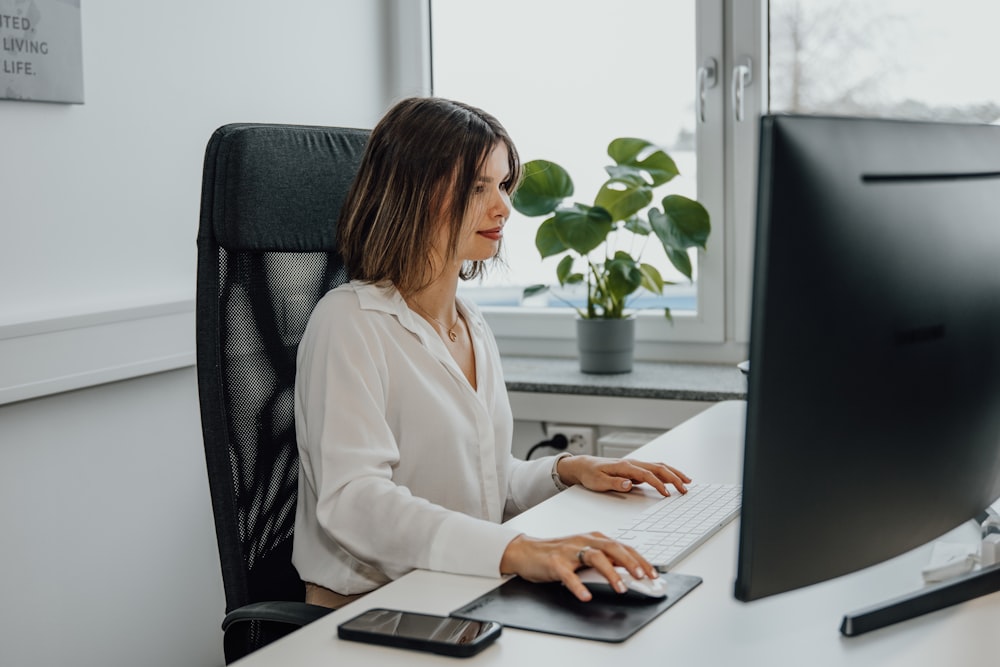 a woman sitting at a desk using a computer