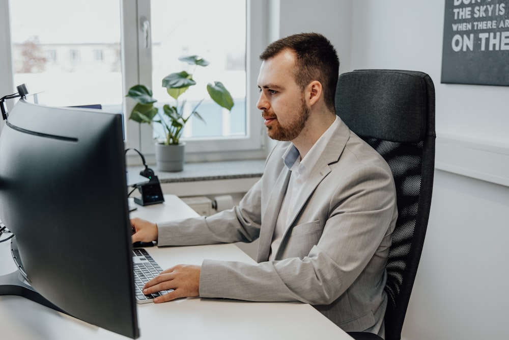 a man sitting at a desk using a computer