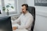 a man wearing a headset sitting in front of a computer