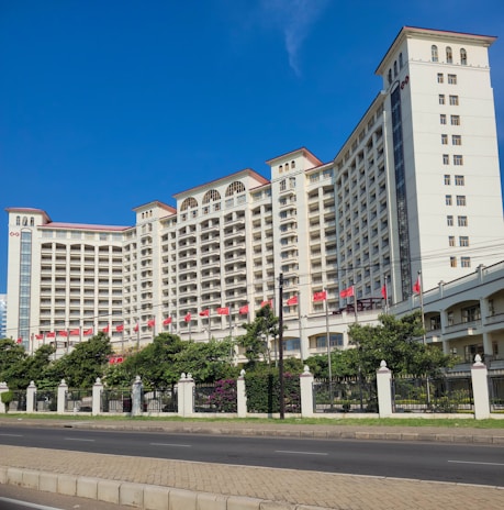 a large white building with red flags on the top of it