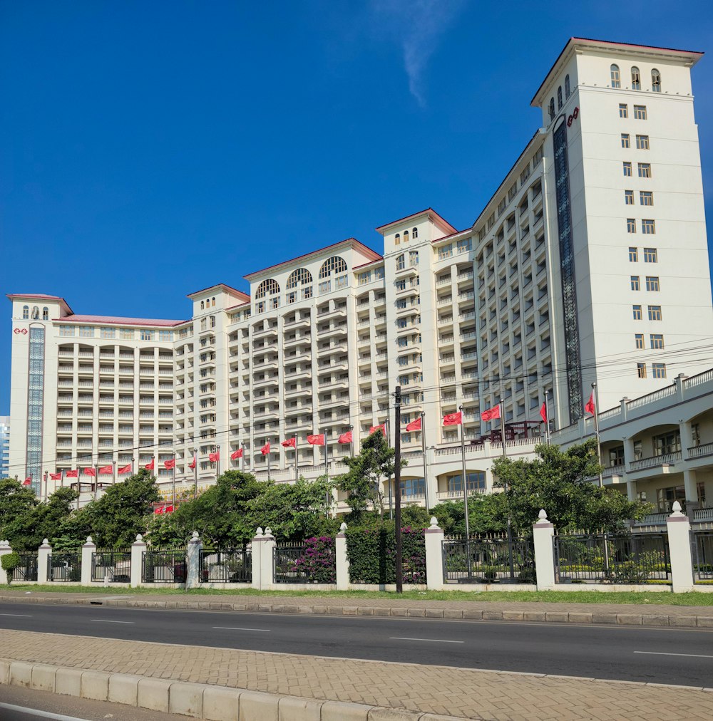 a large white building with red flags on the top of it