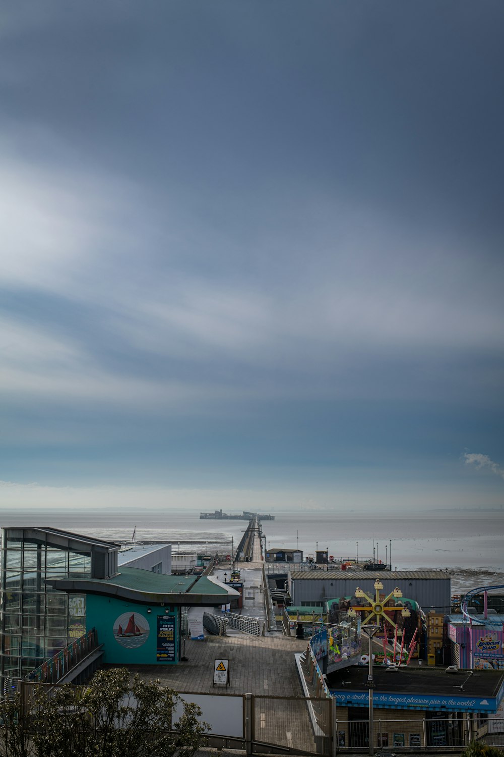 a view of a pier with a ferris wheel in the distance