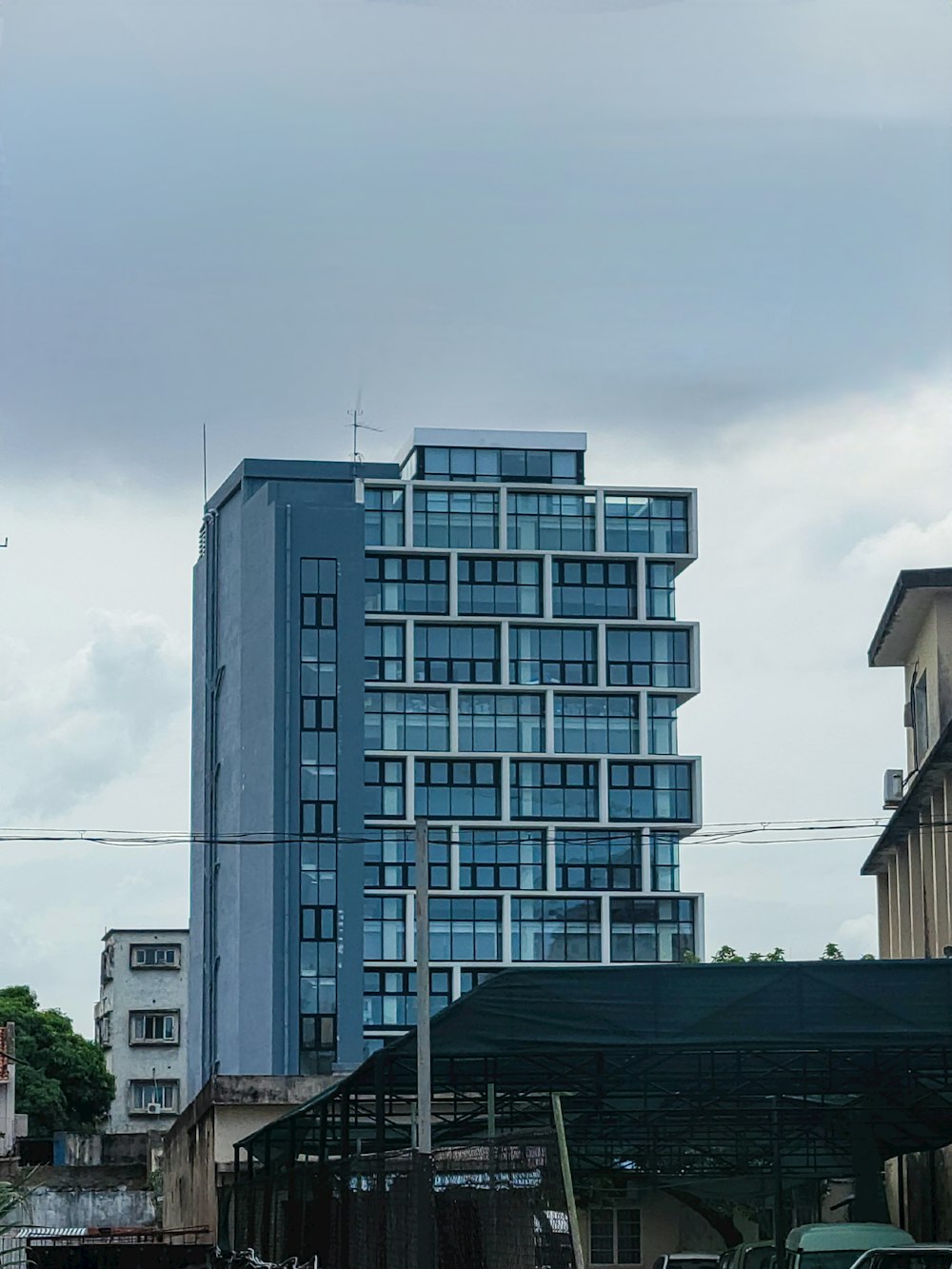 a very tall blue building sitting in the middle of a city