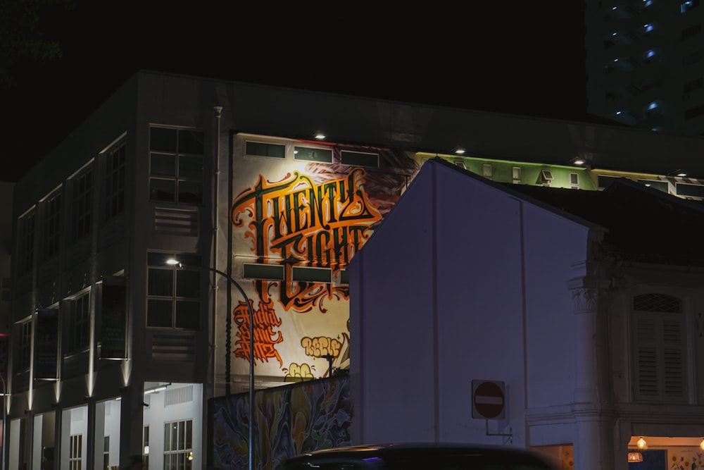 a building with graffiti on the side of it at night