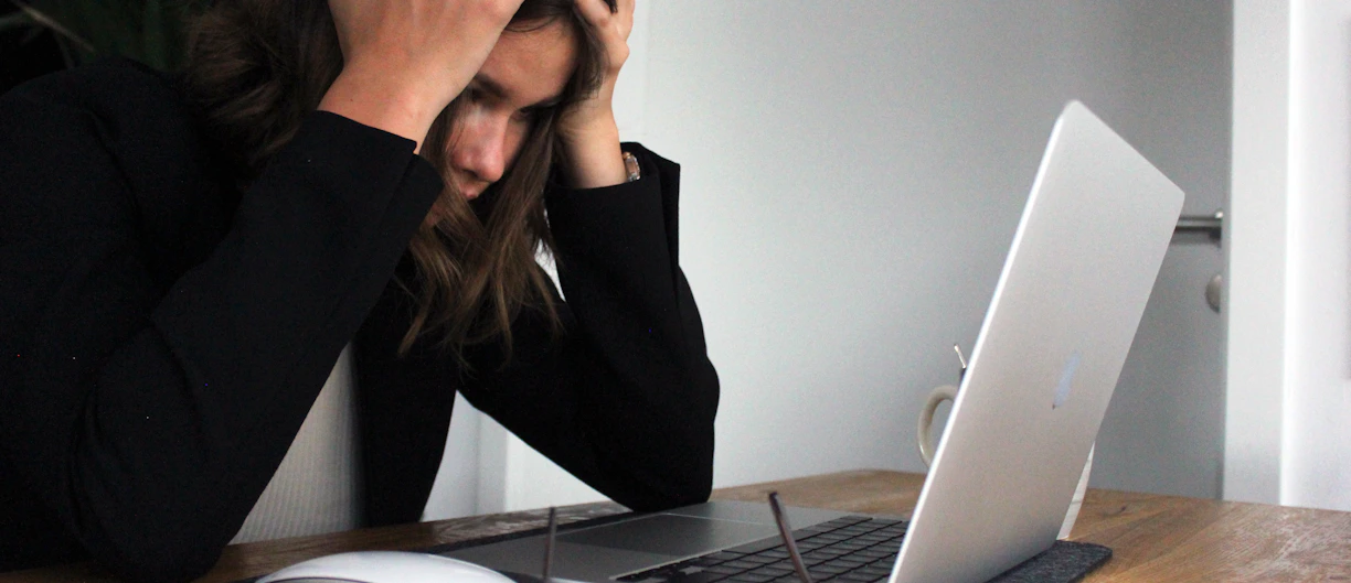 a woman sitting in front of a laptop computer