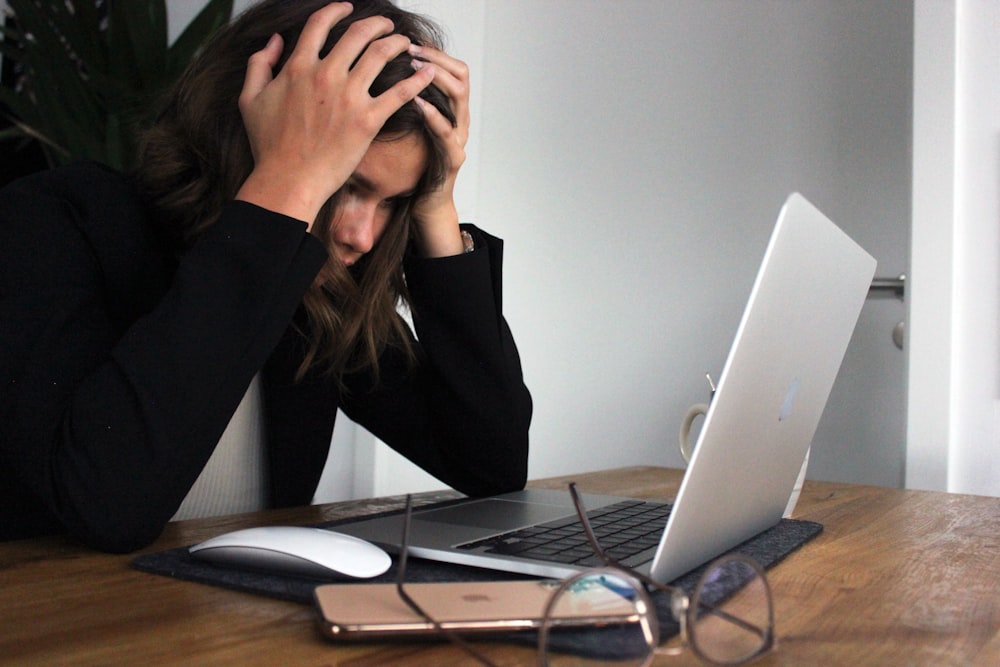 a woman sitting in front of a laptop computer