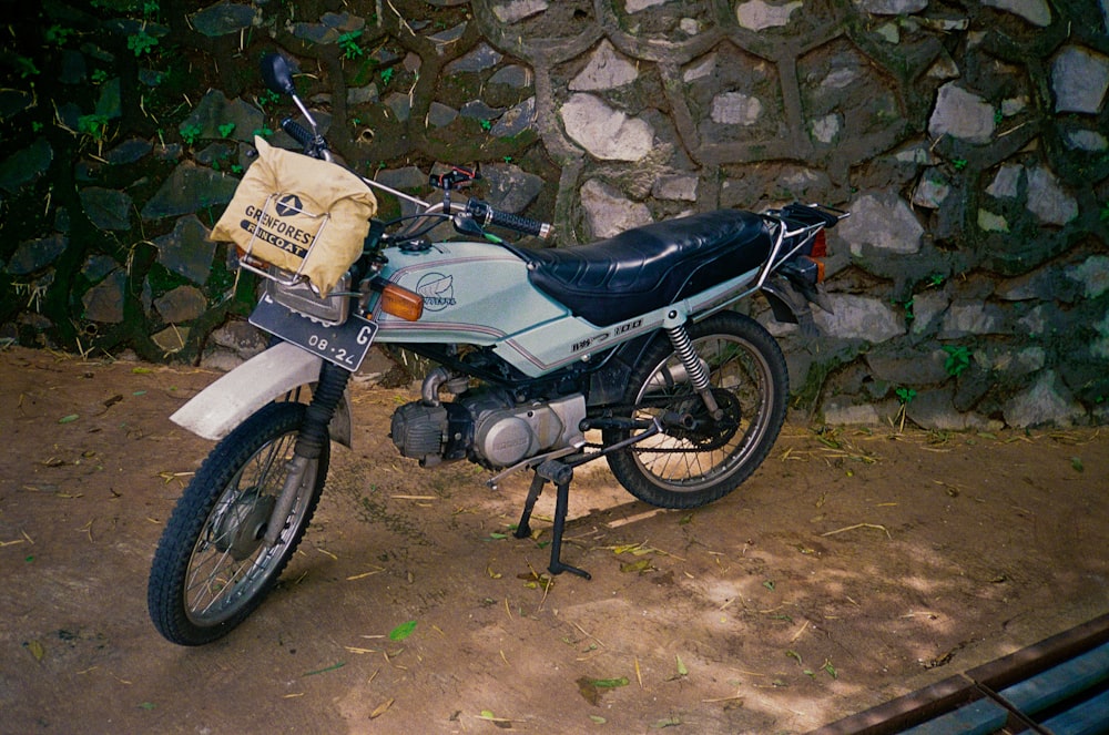 a motorcycle parked next to a stone wall