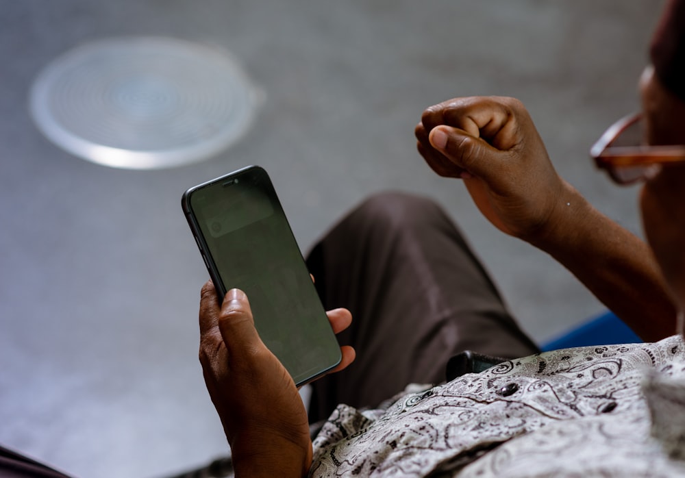 a person holding a cell phone in their hand