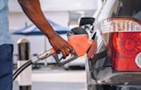 a man pumping gas into his car at a gas station