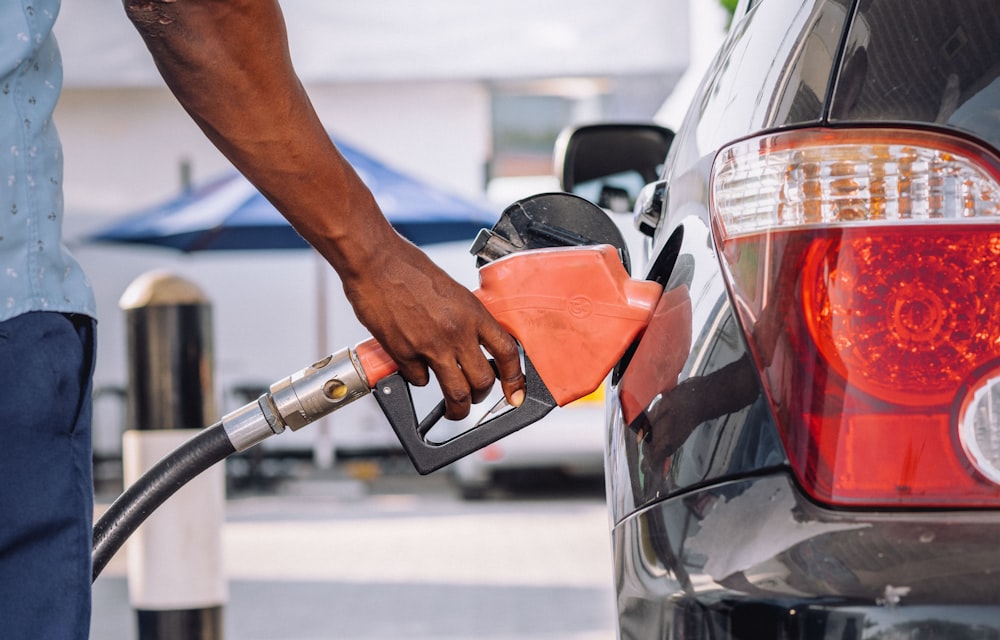 a man pumping gas into his car at a gas station