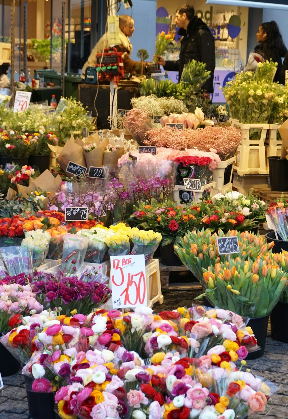 a bunch of flowers for sale in a flower shop