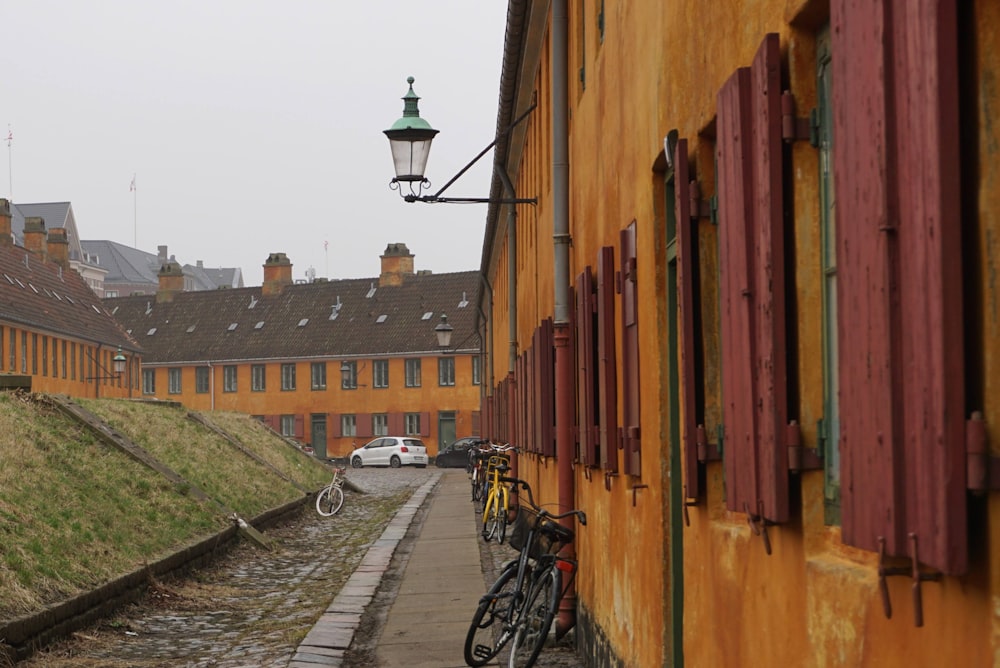 a row of yellow buildings with bicycles parked on the side of the street