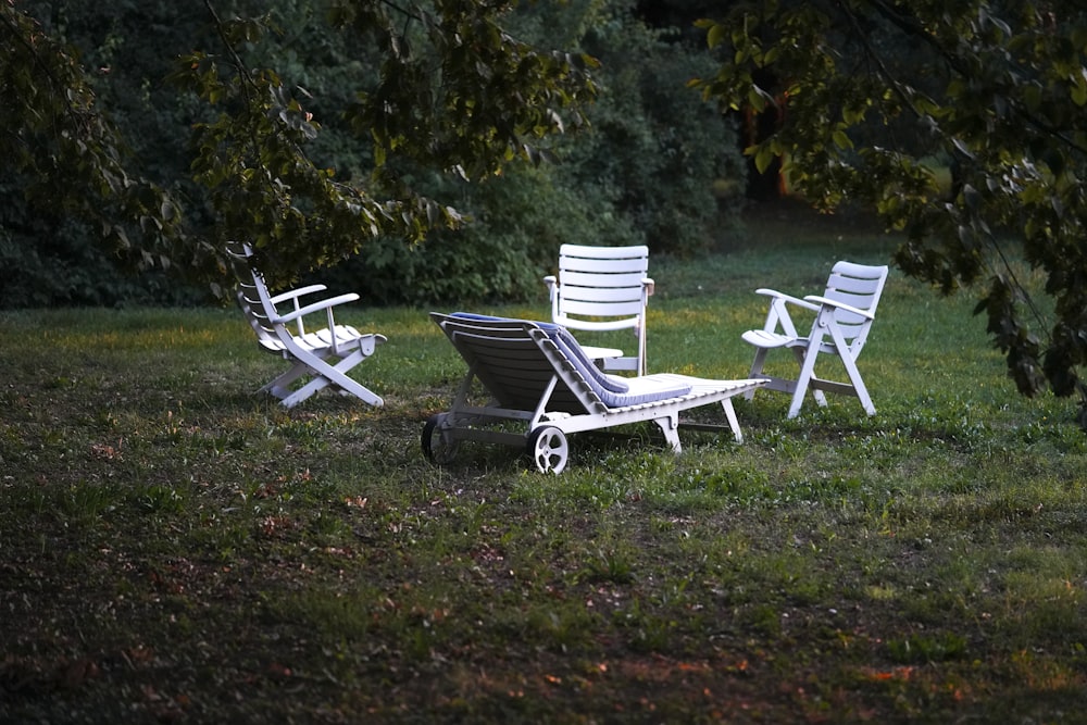 a couple of lawn chairs sitting on top of a lush green field