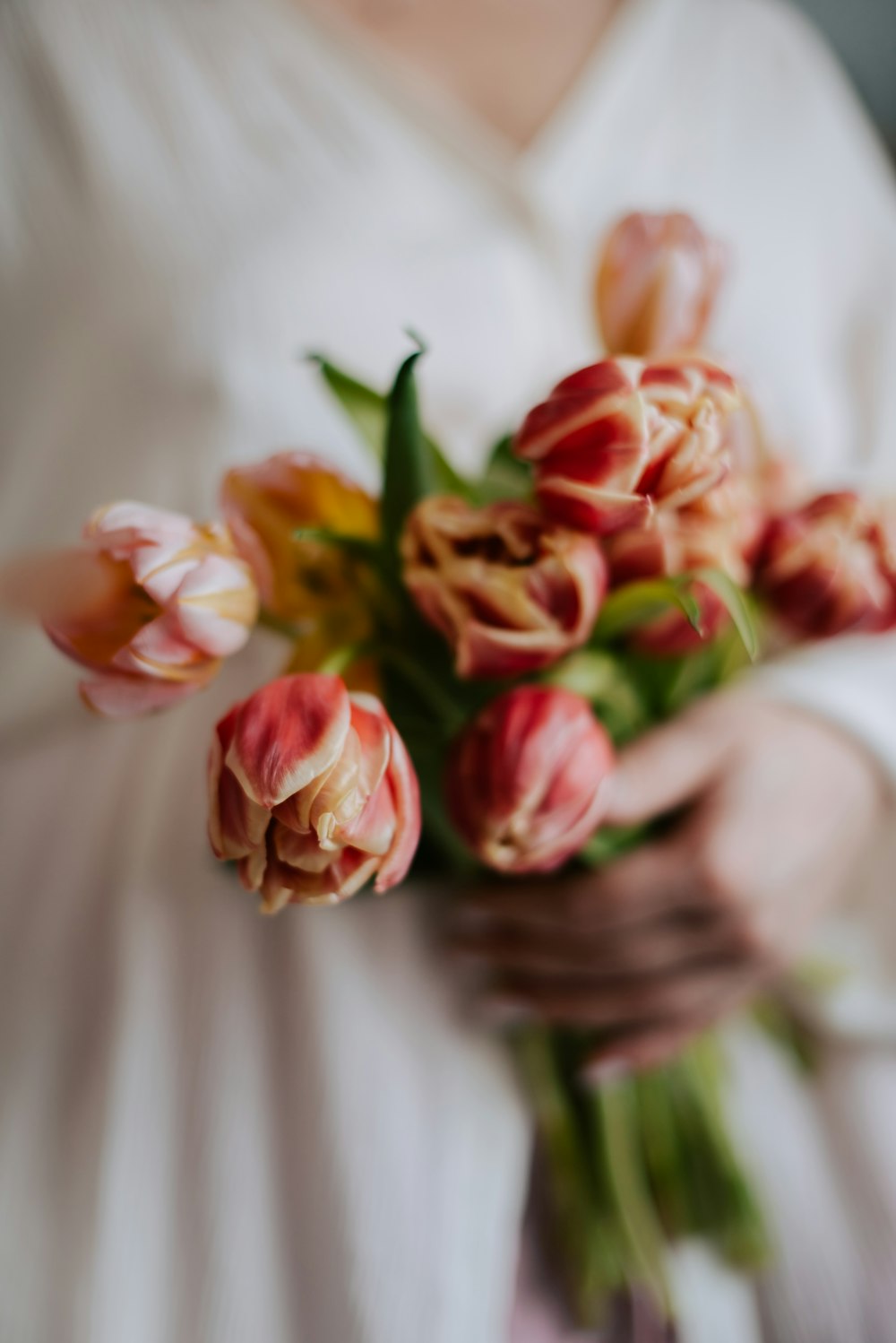 a woman holding a bouquet of flowers in her hands