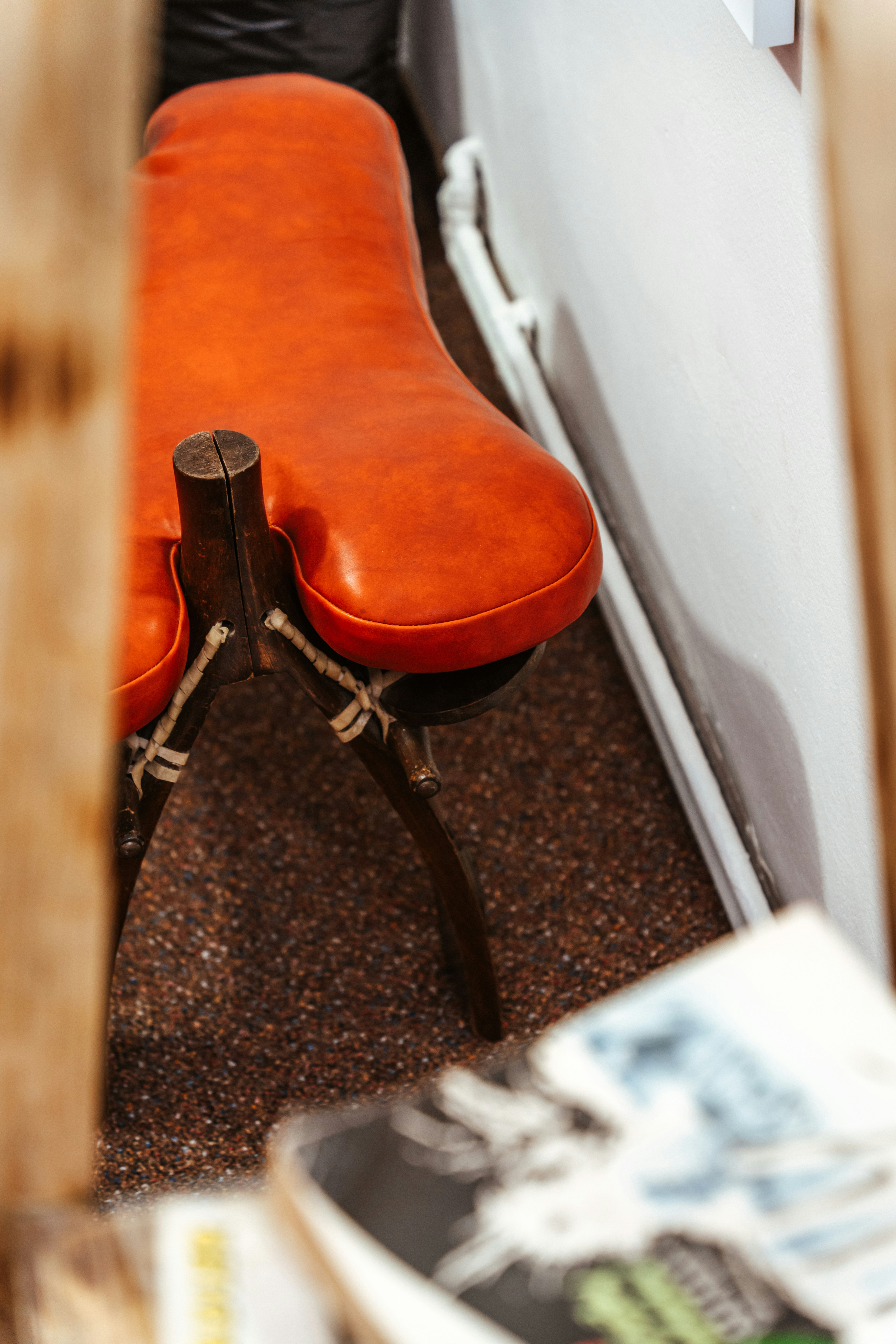 a red bench sitting next to a white wall