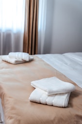 folded towels on a bed in a hotel room