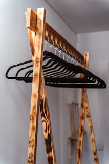 a wooden rack with a coat hanger on top of it