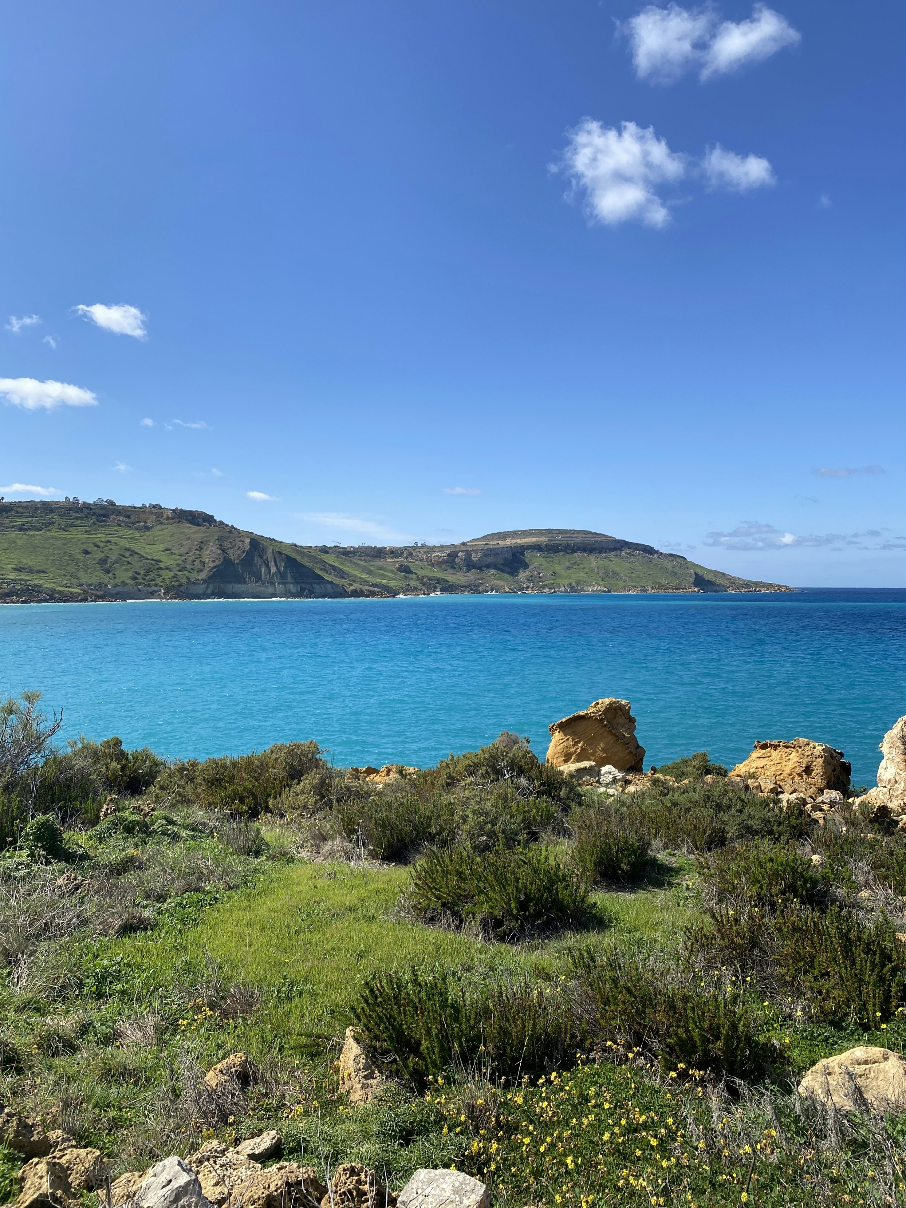 a large body of water sitting next to a lush green hillside