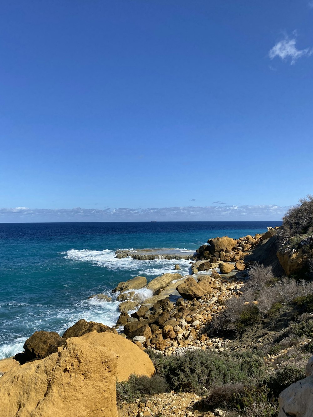 a bench sitting on the side of a cliff near the ocean