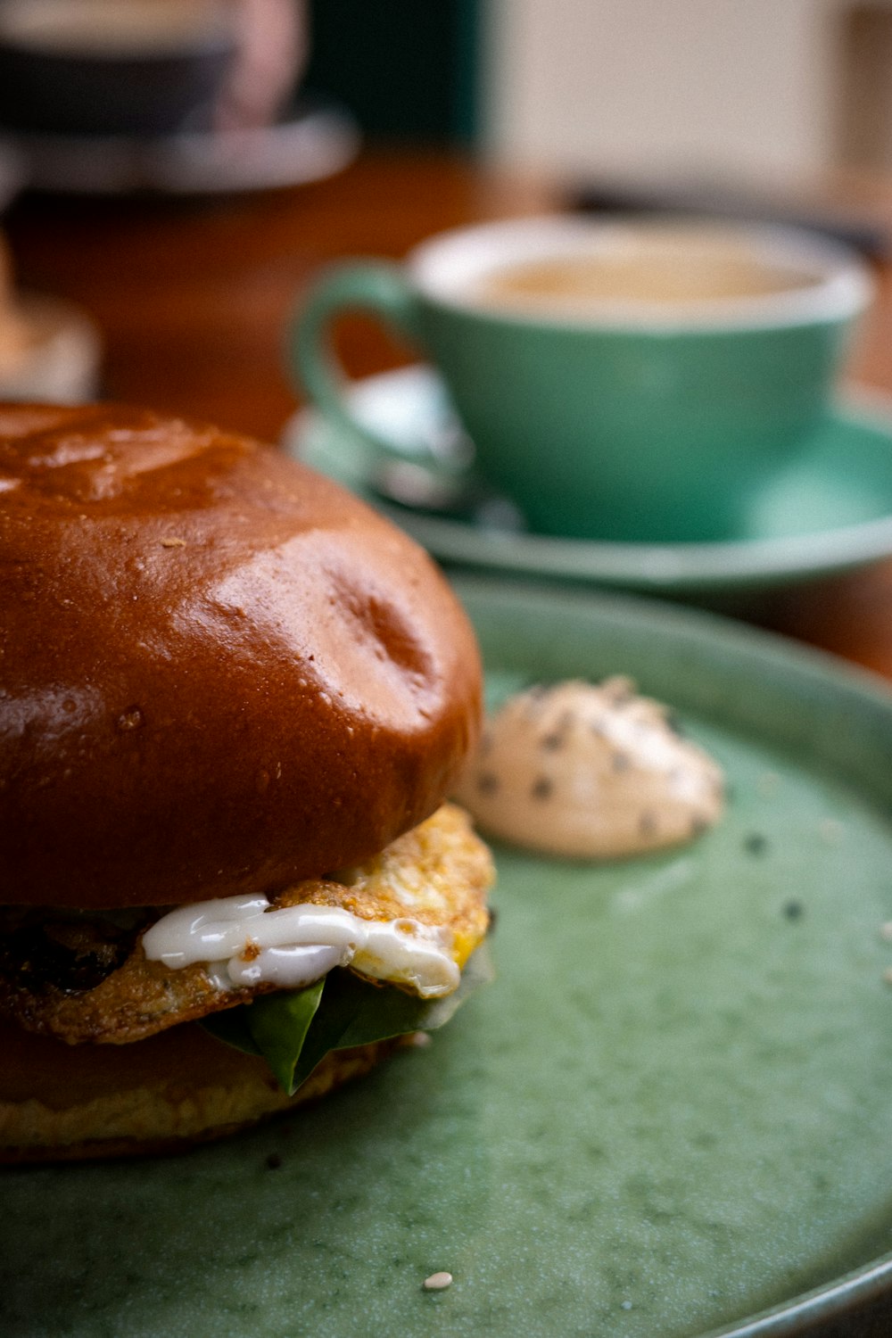 a close up of a sandwich on a plate with a cup of coffee