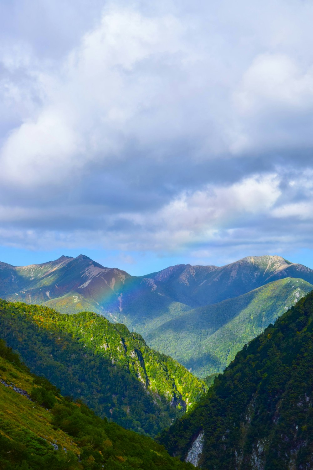 a view of a mountain range with a rainbow in the sky