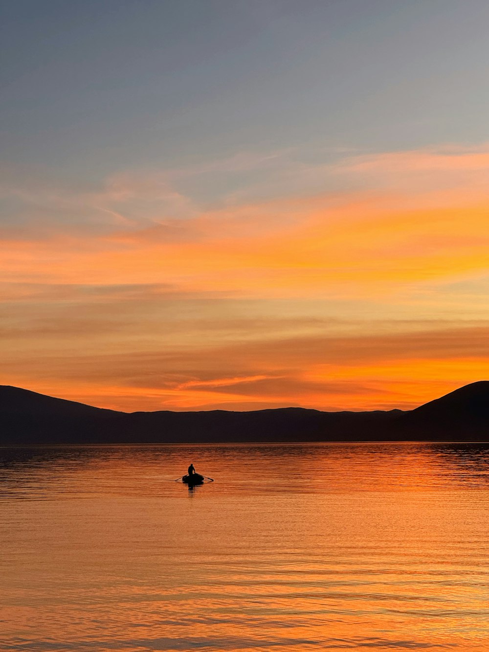 a person on a surfboard in the water at sunset