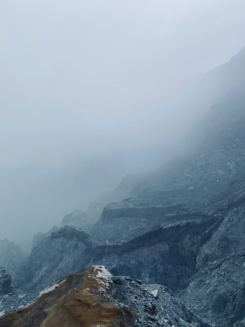 a view of a mountain in the fog