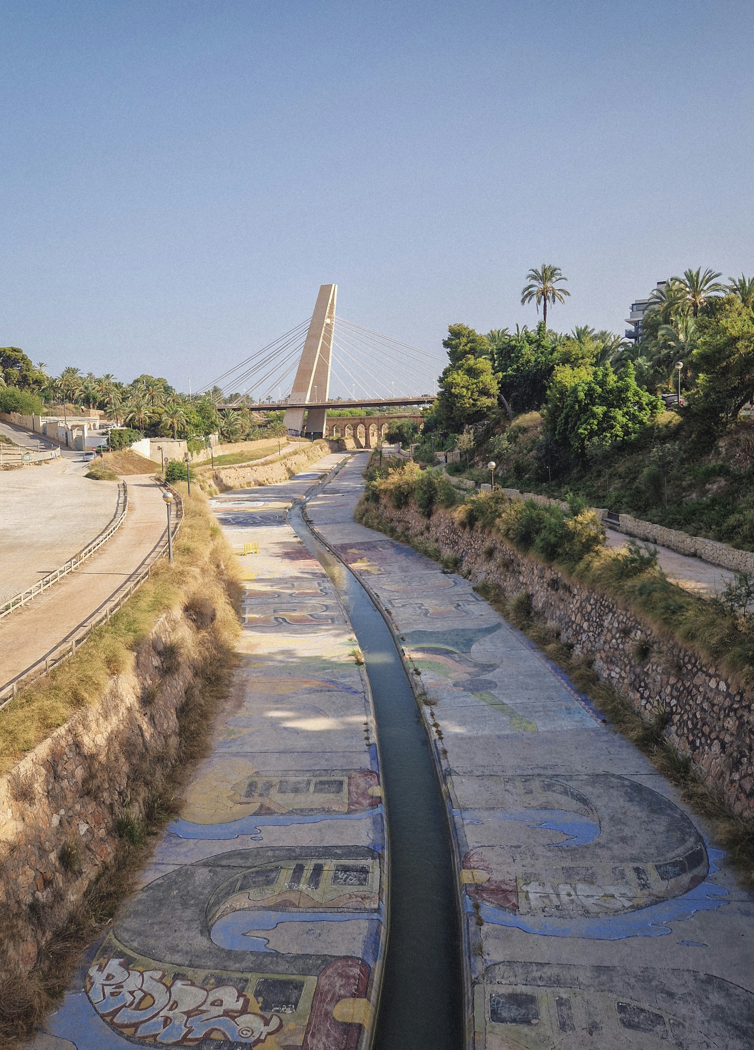 a river running through a park next to a bridge