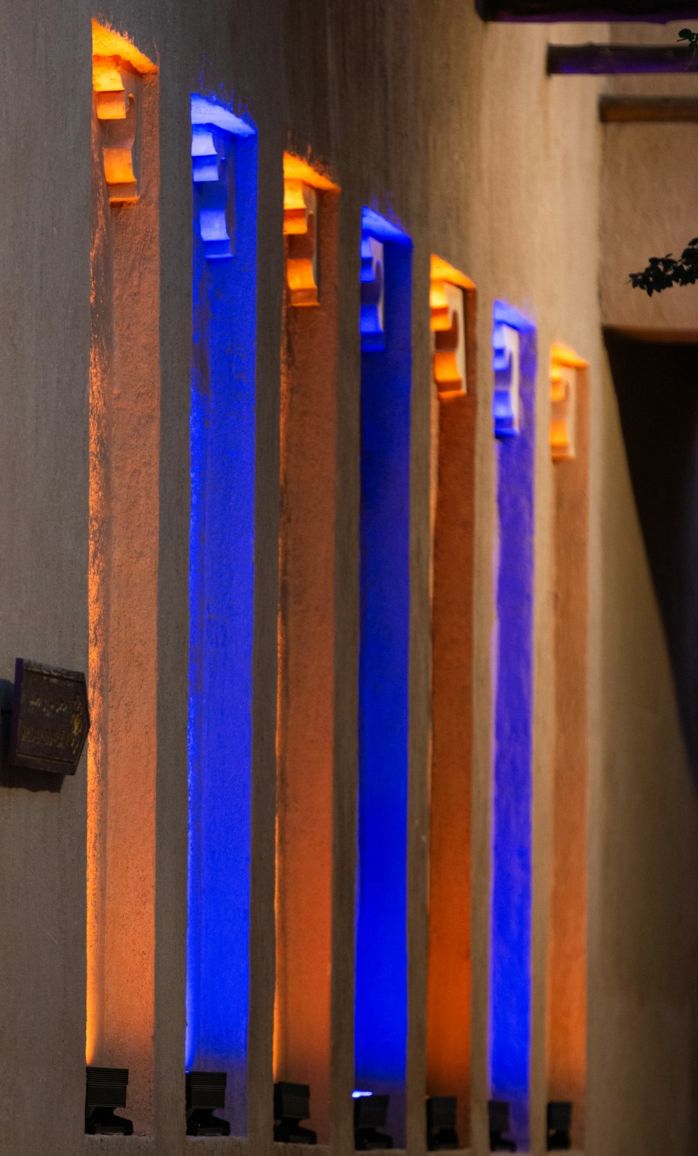 a row of blue and yellow lights on a wall