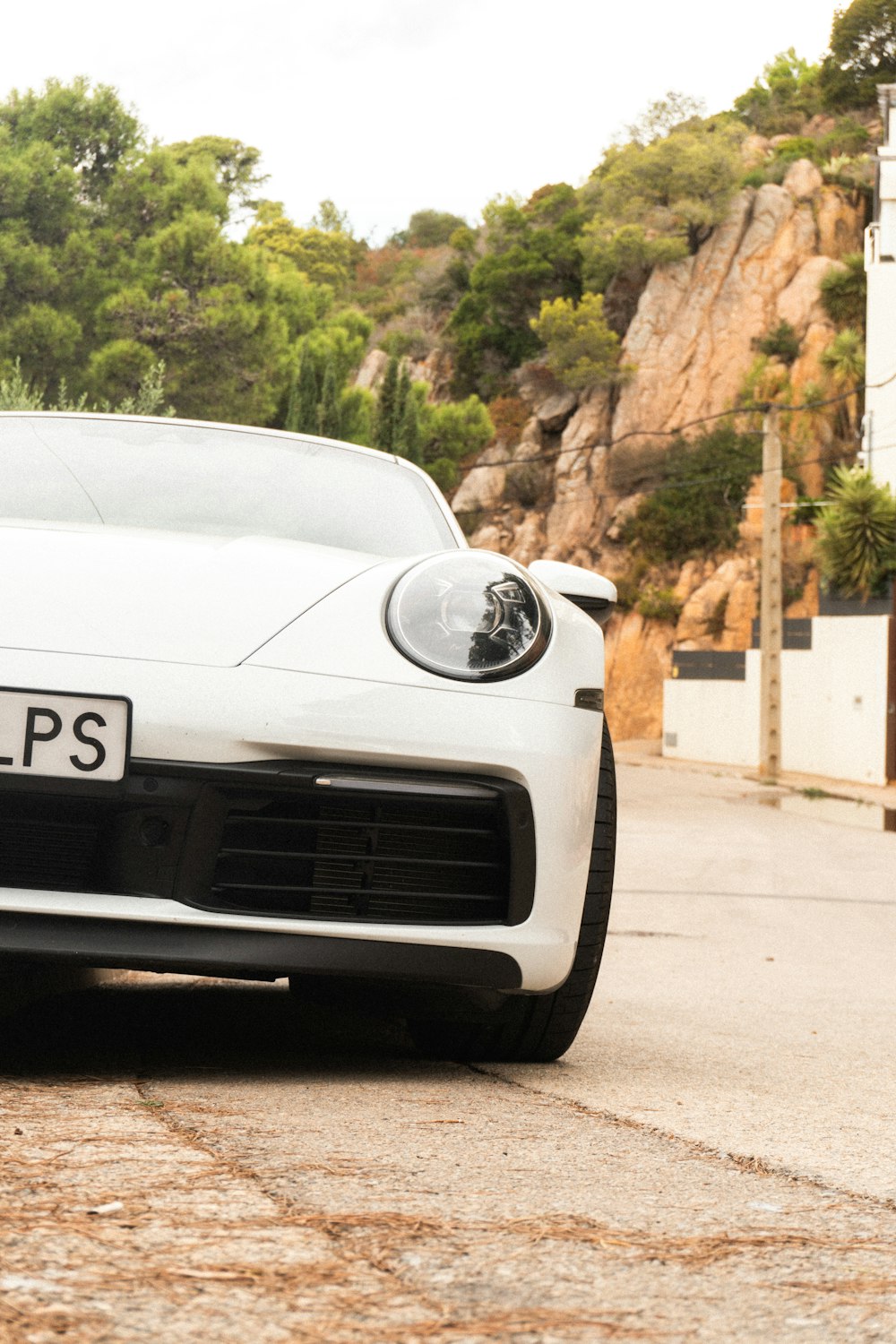 Un coche deportivo blanco aparcado a un lado de la carretera