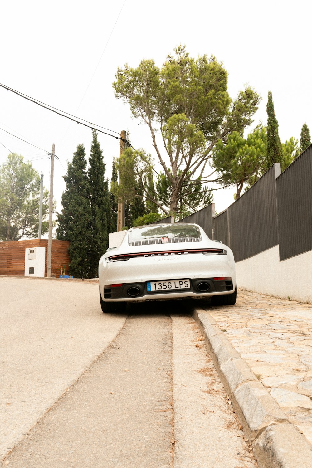 a white sports car parked on the side of a road