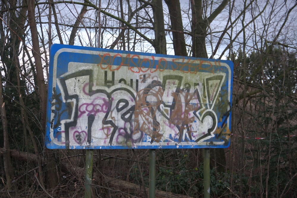 a blue and white street sign covered in graffiti