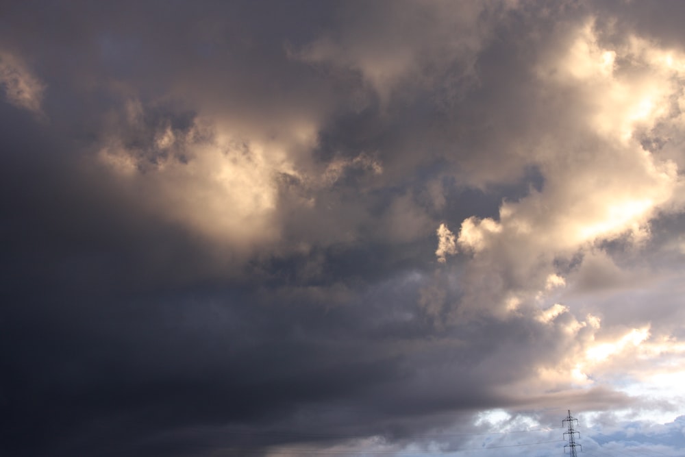 a cloudy sky with a tower in the distance