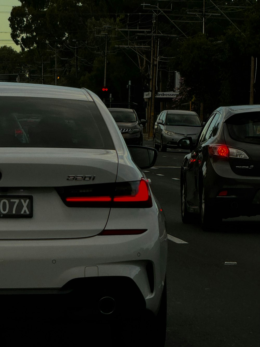 a white car driving down a street next to a traffic light