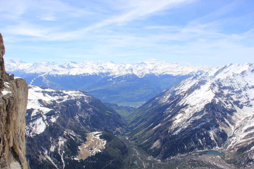 a man standing on top of a mountain next to a cliff