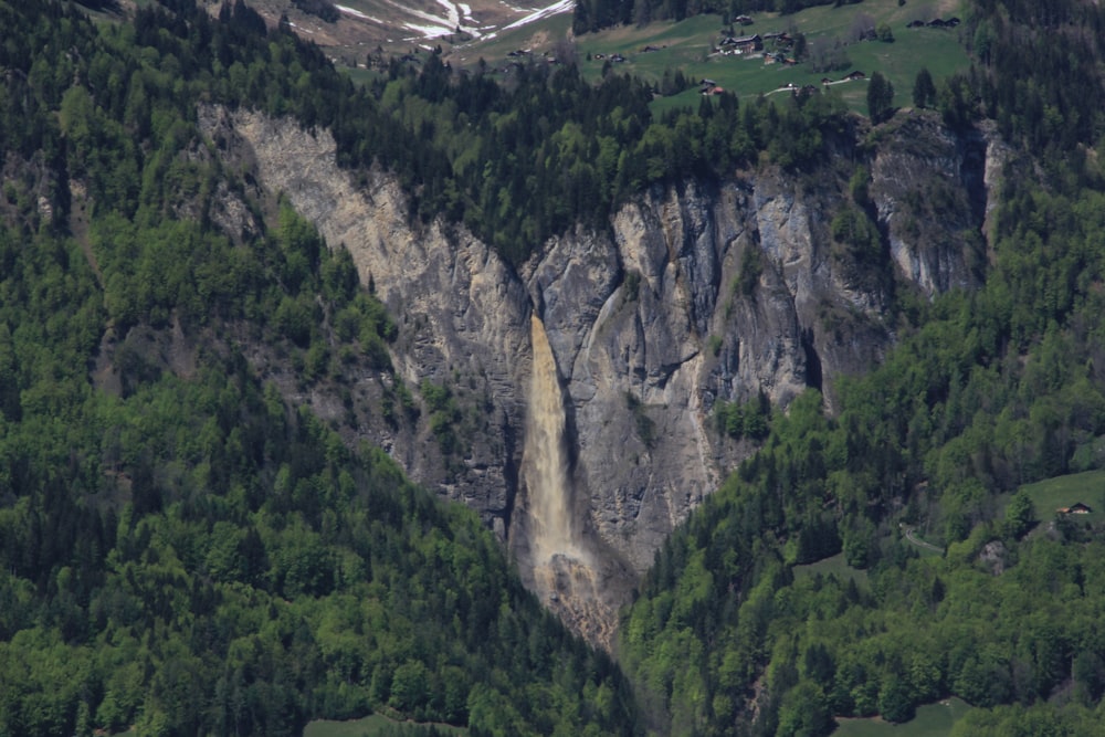 a mountain side with a waterfall in the middle of it