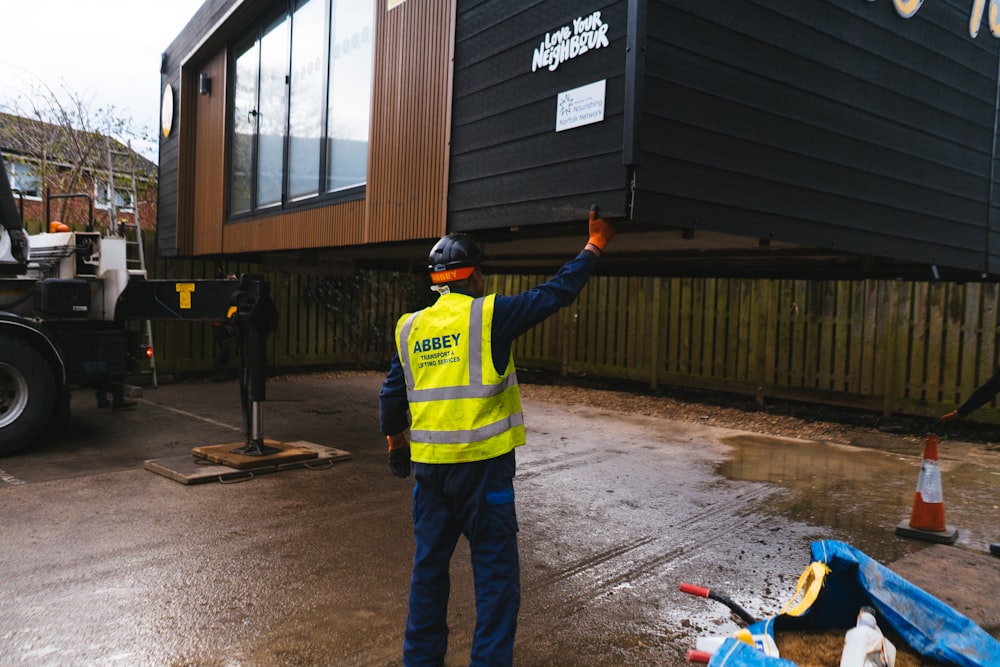 a man in a yellow vest is holding up a container