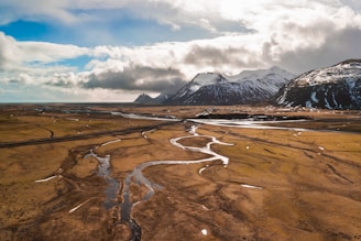 a wide open field with a river running through it