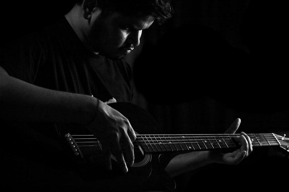 a man playing a guitar in the dark