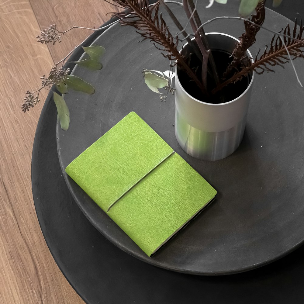 un cuaderno verde sobre una mesa negra