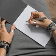 a woman is writing on a piece of paper