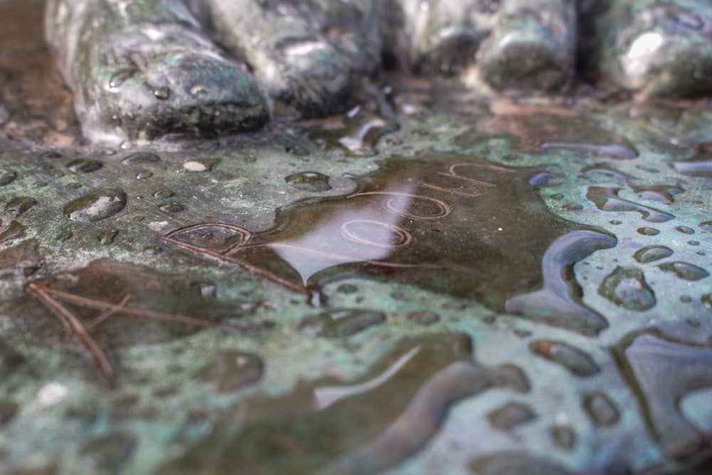 a close up of a water fountain with rocks in the background