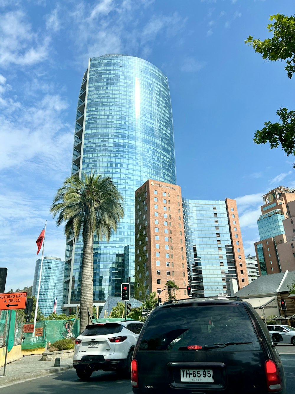 a black car driving down a street next to tall buildings