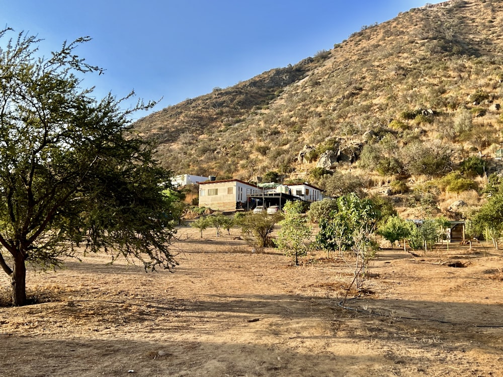 a dirt field with a house in the background