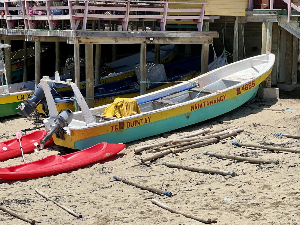 a couple of boats sitting on top of a sandy beach