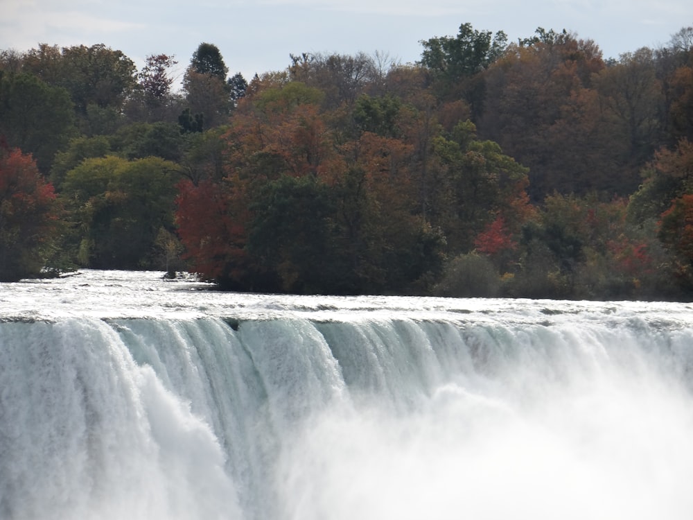 a man riding a surfboard on top of a waterfall